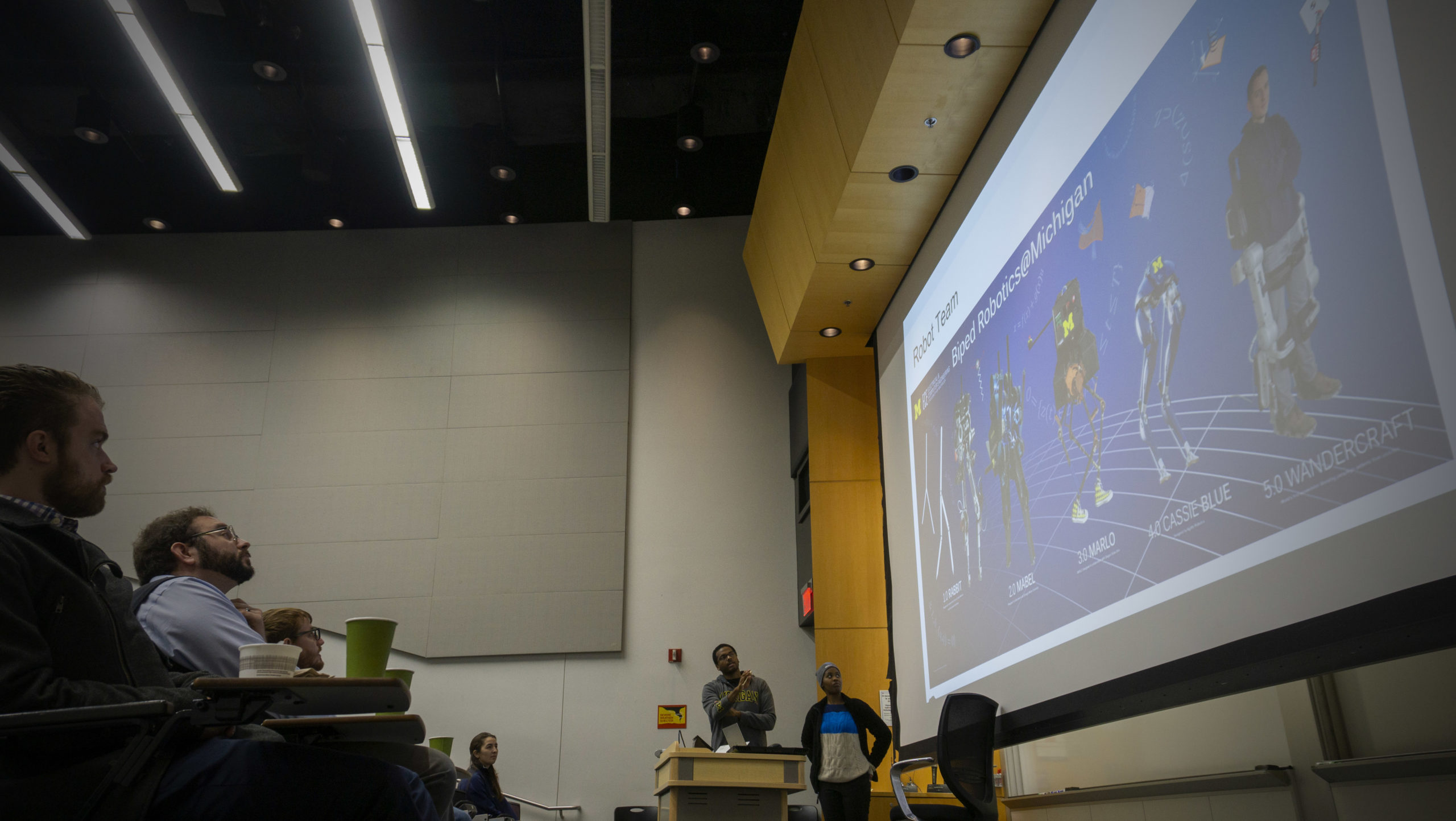 audience looks on at a robotics presentation