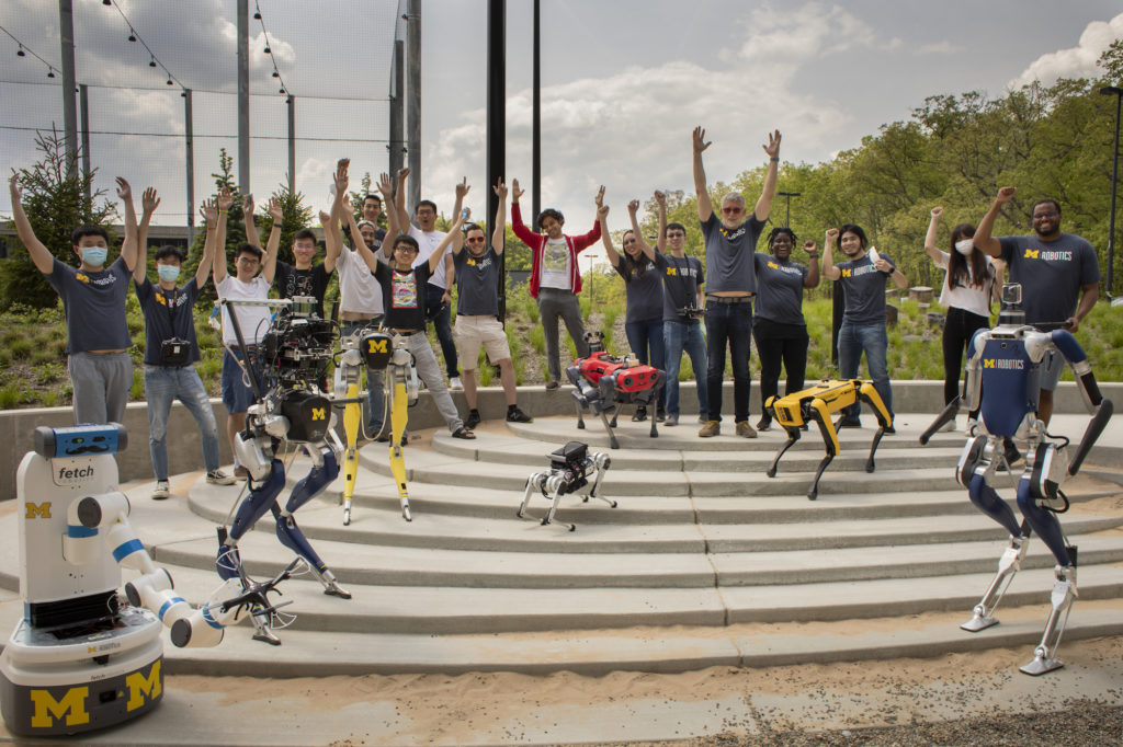 Robots and roboticists cheering in the Robot Garden. Photo by Robert Coelius.